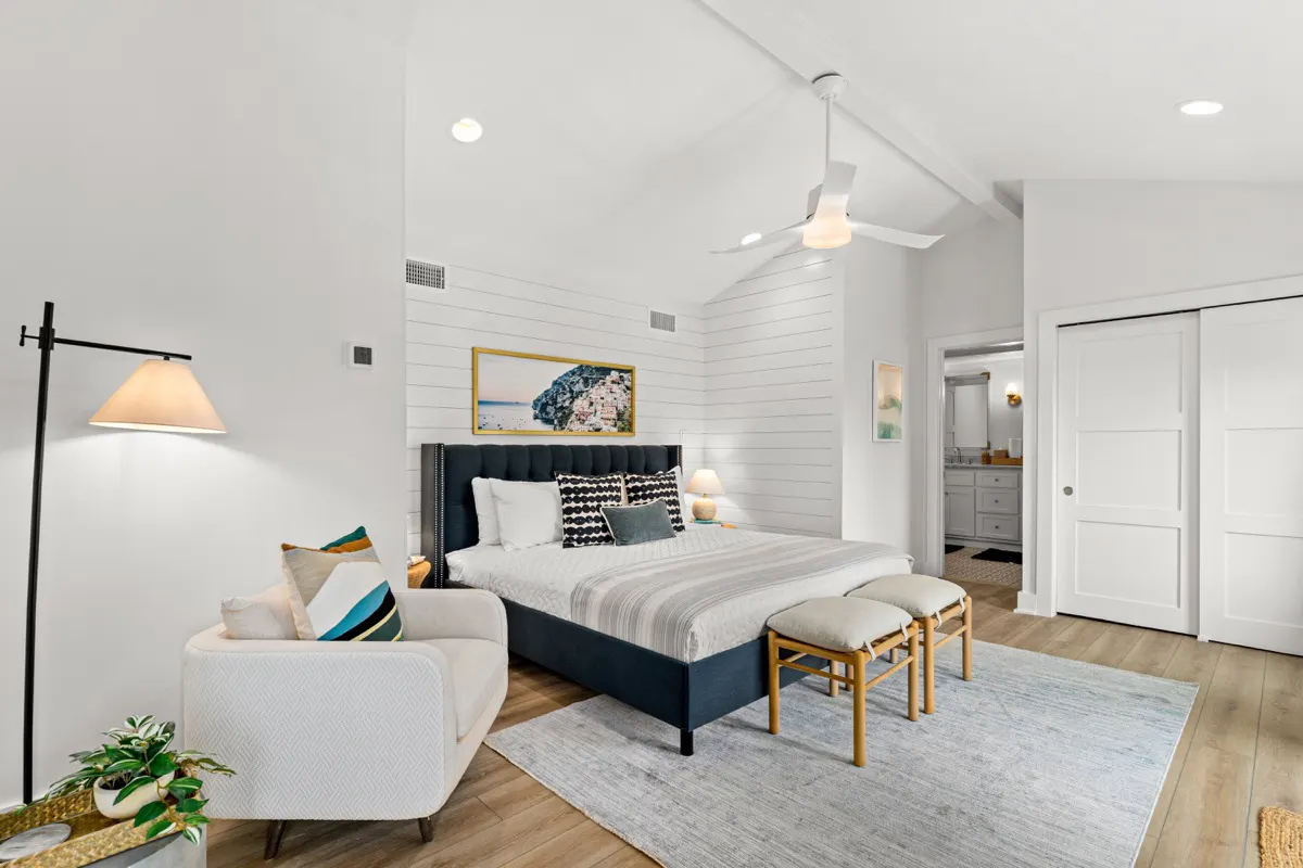 Upstairs primary bedroom with private, ensuite bathroom and screened-in balcony overlooking the backyard